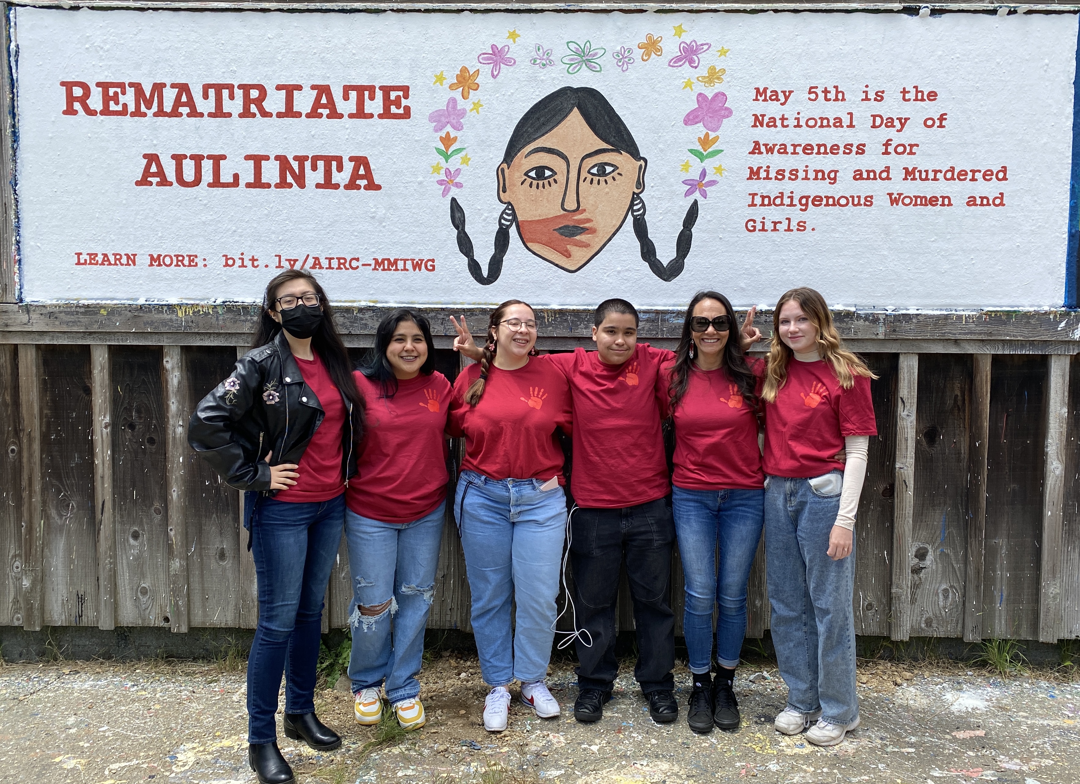 AIRC Team in front of MMIWG banner, "Rematriate Aulinta", painted at the base of UCSC campus, May 2023
